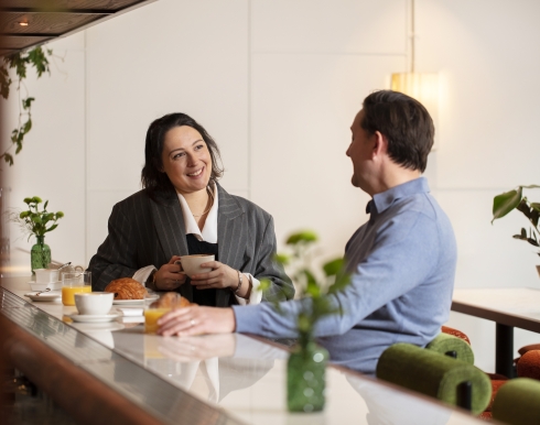 two people sitting at the cardinal bar enjoying breakfast