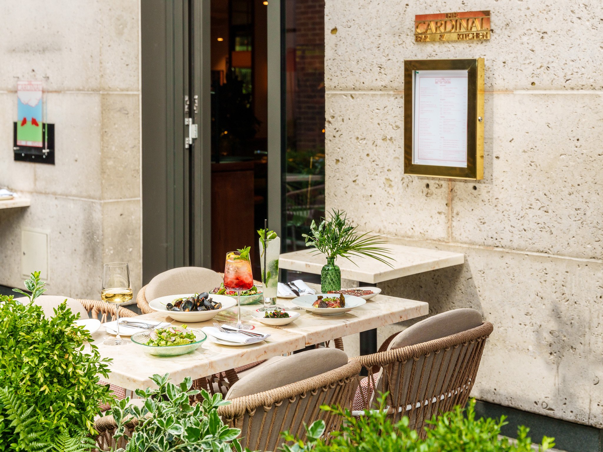 outdoor view of the cardinal bar and kitchen with plates of food on a table