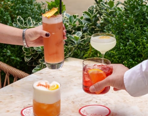 Two people enjoying their cocktails prepared by The Cardinal