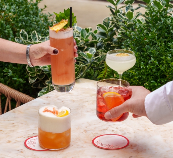 Two people enjoying their cocktails prepared by The Cardinal