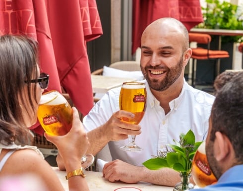 People sitting on the summer terrace drinking Stella Artois pints at The Cardinal Bar & Kitchen
