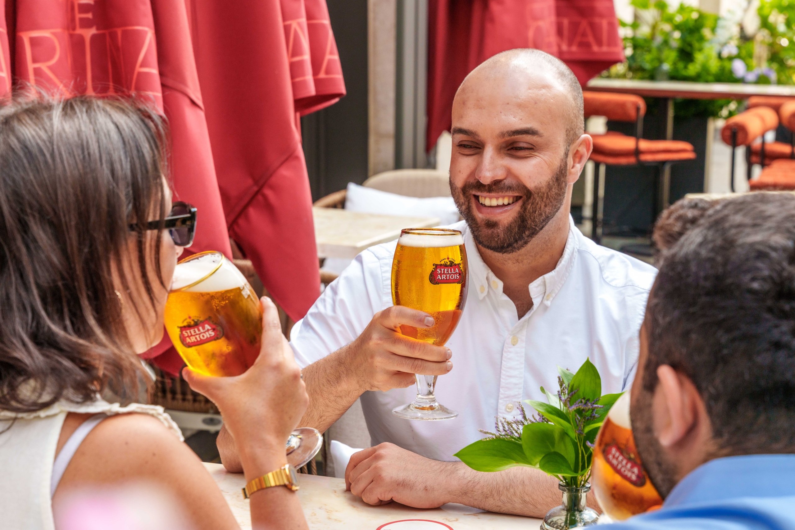People sitting on the summer terrace drinking Stella Artois pints at The Cardinal Bar & Kitchen